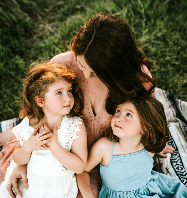 A woman holding two little girls